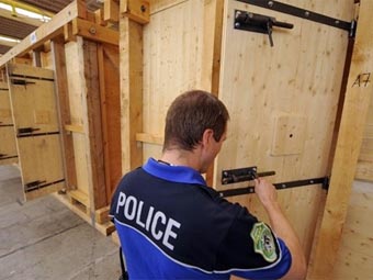 Полицейский проверяет замки камеры для футбольных фанатов. Фото © <a href=_http://lenta.ru/info/afp.htm_ target=__blank_>AFP</a>
