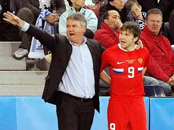 Гуус Хиддинк (слева) и игрок сборной России Иван Саенко. Фото (c)AFP